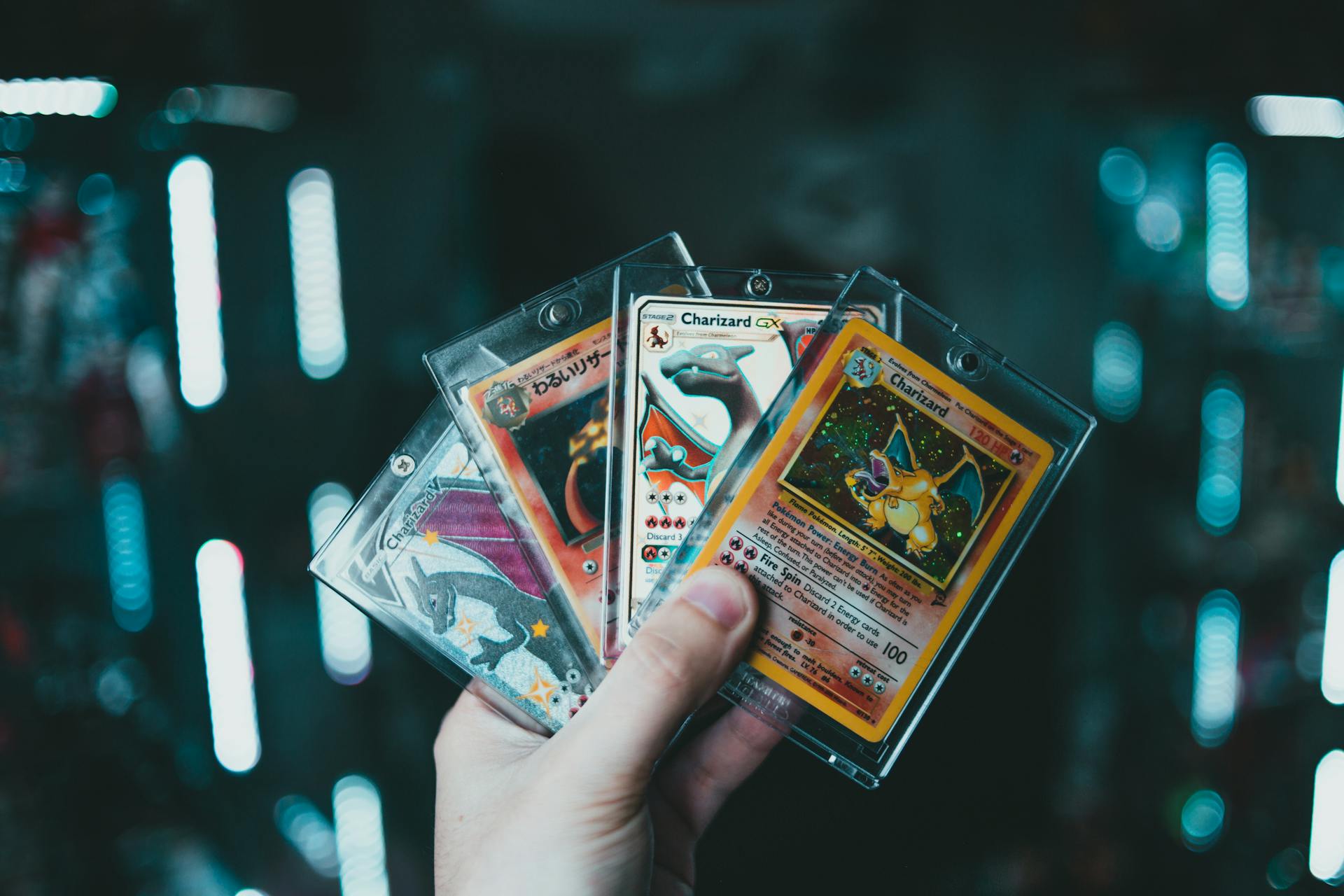 a person holding four Pokemon cards