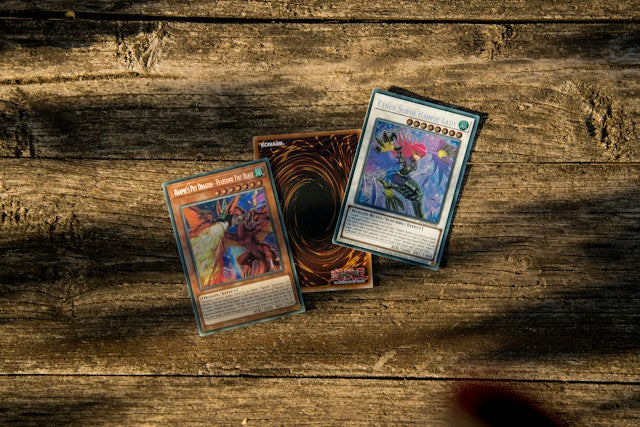 Three Yu-Gi-Oh cards for sale on a table