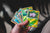 a person holding a hand of trading cards