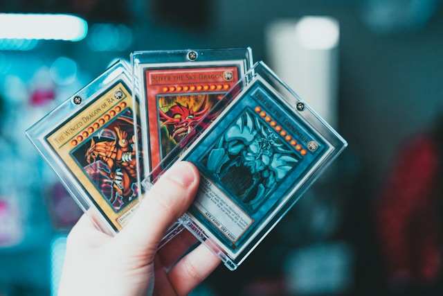 a hand holding three trading cards