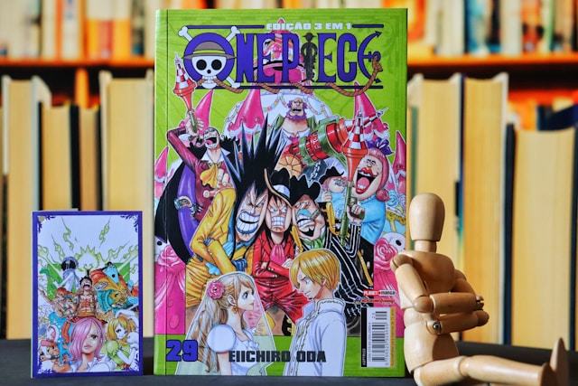 One Piece manga and card next to a wooden figure