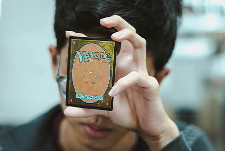 A person holding up an MTG card
