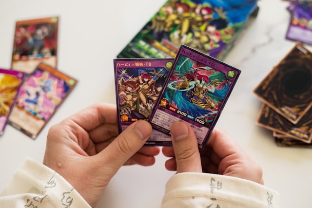 Person holding two Japanese Yu-Gi-Oh! Cards